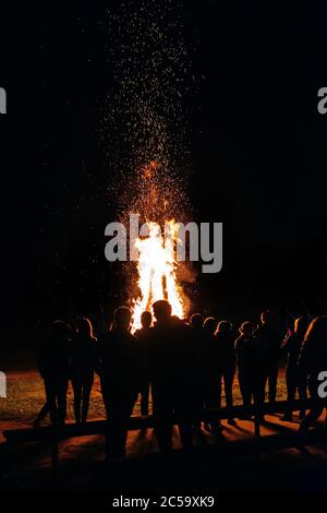 A lot of people have a night fire in the summer vertical Stock Photo