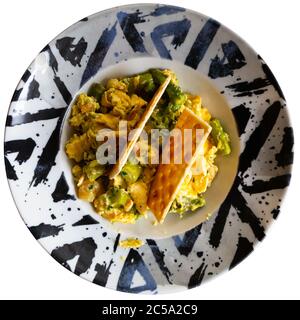 Scrambled eggs with prawns and wild asparagus served with crispbread. Typical Cordoba cuisine. Isolated over white background Stock Photo