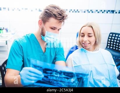 Dentist in mask showing patient dental x-ray Stock Photo