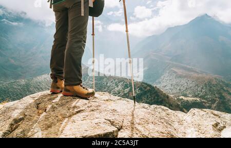 Young hiker female standind in cliff edge and enjoying the Imja Khola valley during an Everest Base Camp (EBC) trekking route near Tengboche. Hiker us Stock Photo
