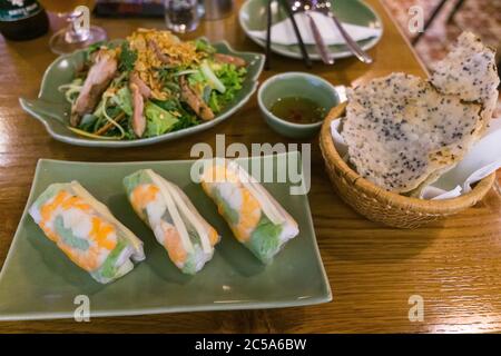 Fresh Vietnamese shrimp spring rolls, salad, and sesame rice crackers served at a restaurant in Ho Chi Minh City, Vietnam. Stock Photo