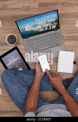 High angle of a male sitting on the floor with his Electronic Devices - Smartphone, Laptop Computer and Tablet. Unrecognizable person casually dressed Stock Photo