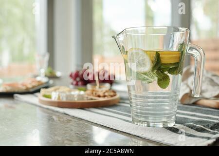 Close-up of glassy pitcher of lemonade on stripped napkin prepared for dinner party at home Stock Photo