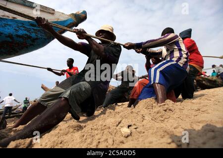 Fishermen tug a boat ashore oat James town fishing village in Accra, Ghana. September 4, 2009. Stock Photo