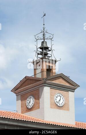 Tower made of red bricks with a bell on its top and clocks on its sides Stock Photo