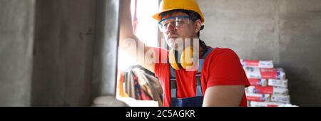 Builder measures level wall at construction site Stock Photo