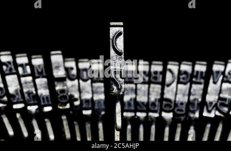 Macro closeup of isolated type bars of old typewriter with letters and symbols, black background Stock Photo
