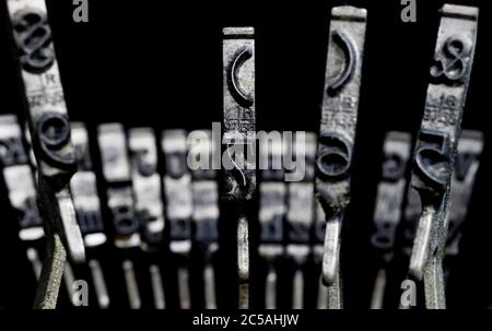 Macro closeup of isolated type bars of old typewriter with letters and symbols, black background Stock Photo