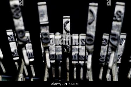 Macro closeup of isolated type bars of old typewriter with letters and symbols, black background Stock Photo