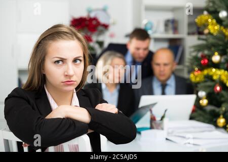 Business team tensely solving problems in office with upset woman foreground Stock Photo