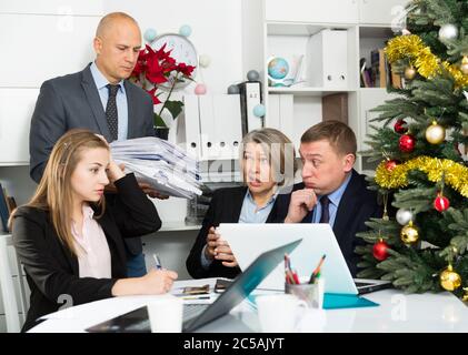 Group of dissatisfied employees looking at managing director with pack of new documents for work Stock Photo