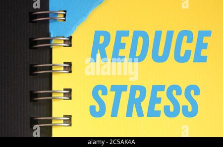 Reduce stress text written in copybook page blue on yellow. Calm and Slow down concept Stock Photo