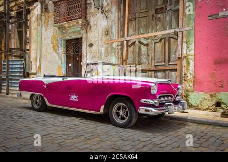 Havana, Cuba, July 2019, purple 50s rental Dodge car parked in the street in the oldest part of the city