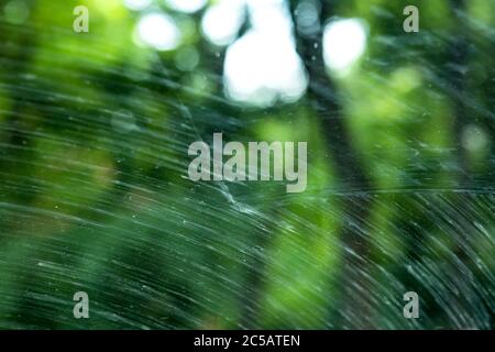 windshield of a dirty car in mud smeared by car wipers close up. Stock Photo