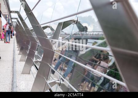 glass bridge with tension steel cables and steel railing supports with reflection on glass. Stock Photo