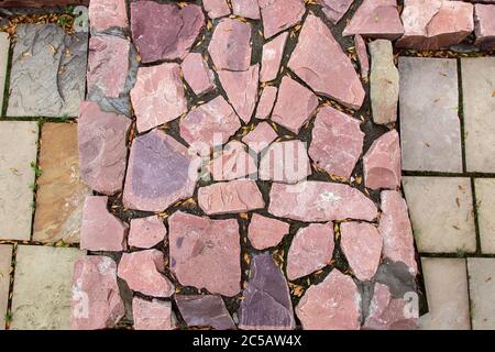 cobblestone pavement made of red rough stone, texture top view. Stock Photo