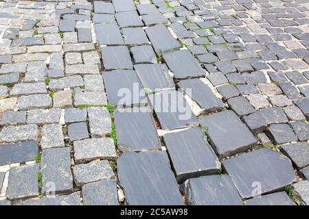 hardscape sett cobblestone old roadway on historical europe city, close up footpath texture nobody. Stock Photo