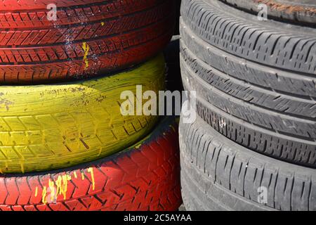 Tires. Red, yellow car tires vertically stacked / piled up. Good background for business card for the tire business. Picture for tire business card. Stock Photo