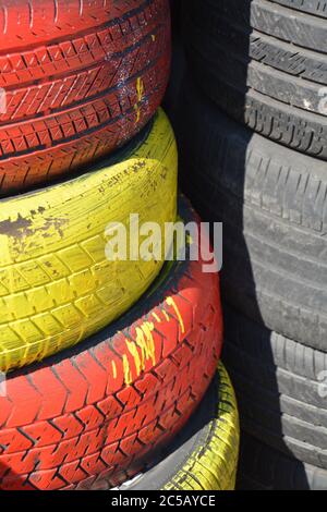 Tires. Red, yellow car tires vertically stacked / piled up. Good background for business card for the tire business. Picture for tire business card. Stock Photo