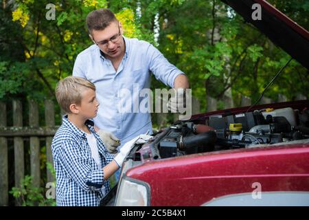 Father teaching his son how to repair the car Stock Photo