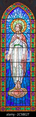 BARCELONA, SPAIN - MARCH 4, 2020: The modern stained glass of Virgin Mary in church Iglesia Sant Angel Custodi from 20. cent. Stock Photo