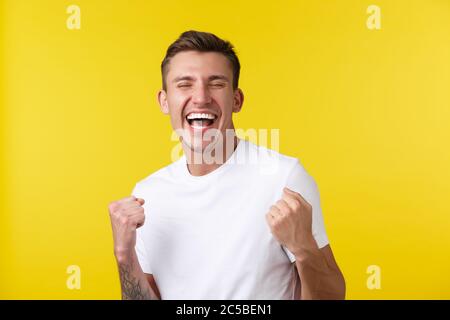 Lifestyle, summer and people emotions concept. Close-up portrait of rejoicing handsome happy guy feeling relieved over super good news, achieve goal Stock Photo