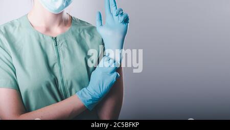 Medical Doctor in Personal Protective Equipment on Isolated Background, Closeup of Female Doctor is Wearing Face Mask and Medic Latex Gloves for Patie Stock Photo