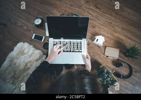 Work From Home for Social Distancing in Coronavirus Covid-19 Situation, Woman Designer Using Laptop on Flooring Carpet at Her Home. Above View of Crea Stock Photo