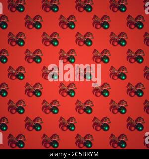 Red Christmas pattern. Red and green satin glass Christmas bulbs on red background Stock Photo