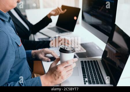 Working in the morning with businessmen are dipping coffee that works with software developers to analysis together the code written in the program on Stock Photo