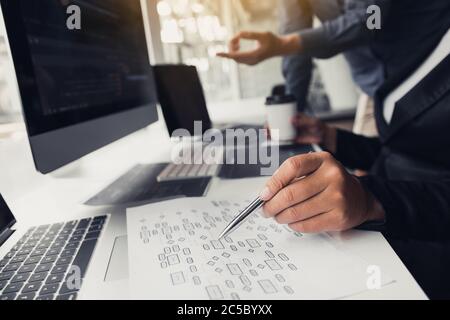 Two partnerships developing programming and coding technologies working on laptop and analyzing together. Stock Photo