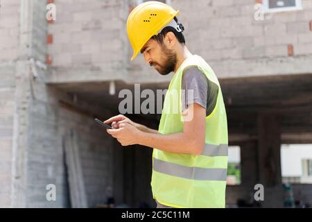 builder with van checking text messages on mobile phone Stock Photo