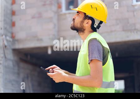 builder with van checking text messages on mobile phone Stock Photo