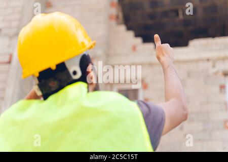 Project manager showing thumbs up sign at construction site Stock Photo