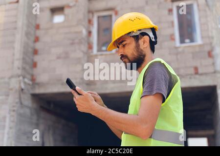 Real construction worker using mobile telephone Stock Photo