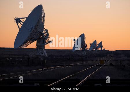 Row of radio antennas after sunset at the VLA in New Mexico Stock Photo