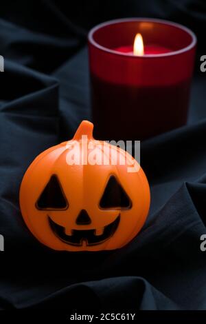 Halloween pumpkin with red candle on dark background. Jack o lantern. Festive gift card,  holiday decoration. The Western Christian feast of All Hallo Stock Photo