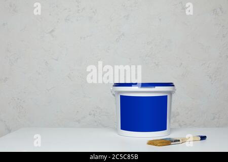 Closed blank blue can of paint and brush on table. Mockup for design. space for text Stock Photo