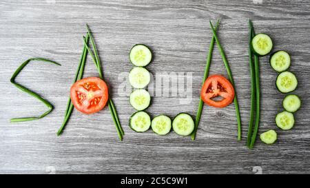 Word SALAD made of green onion cucumber and tomato, healthy vegan eating, low Stock Photo