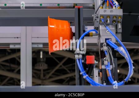 Automatic pick and place robotic arm manipulator with suction cups moves polypropylene pots - part of plastic injection molding machine at exhibition Stock Photo