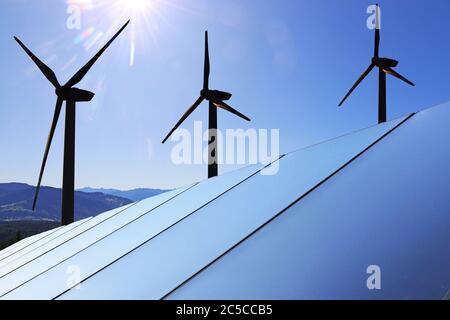 Symbolbild Energiewende: Solardach mit Windkraftanlagen im Hintergrund (Composing) Stock Photo