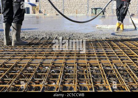 Betonieren einer Bodenplatte mit Fertigbeton bzw. Transportbeton auf der Baustelle eines Wohnhauses Stock Photo