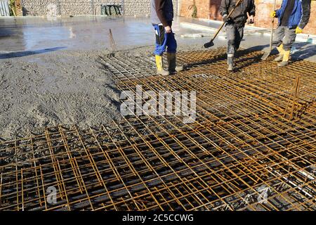 Betonieren einer Bodenplatte mit Fertigbeton bzw. Transportbeton auf der Baustelle eines Wohnhauses Stock Photo