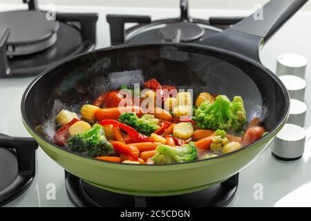 Close-up of frying vegetables in a pan on a gas stove. Stock Photo