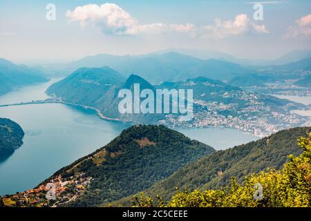 The village of Bre, Lugano Lake , and famous mountains of this area. Beautiful aerial view of a large lake, Swiss village and surrounding  mountains. Stock Photo