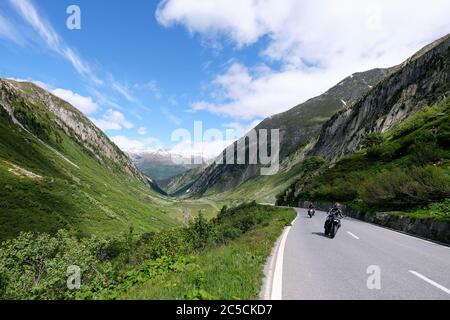 Motorcyclists on the Nufenen Pass in the Swiss Alps, which connects the cantons of Valais and Ticino, Switzerland. Stock Photo