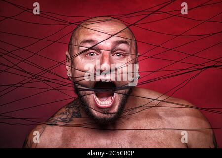 Photo of tangled in black threads bald man Stock Photo
