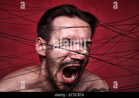Photo of tangled in black threads brunette man Stock Photo