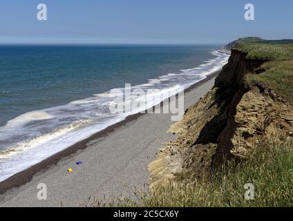 View east along the eroding clay cliffs of Norfolk towards Sheringham showing the rapidly eroding boulder clay cliff and shingle beach. Stock Photo
