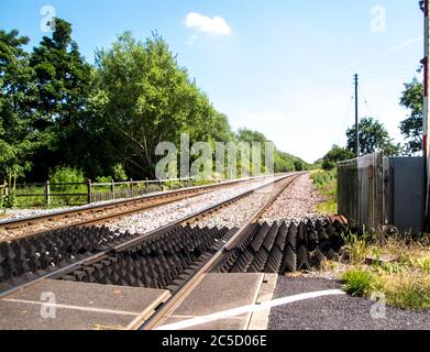 A typical railway line crossing in the United Kingdom, on a dry summer's day. Stock Photo